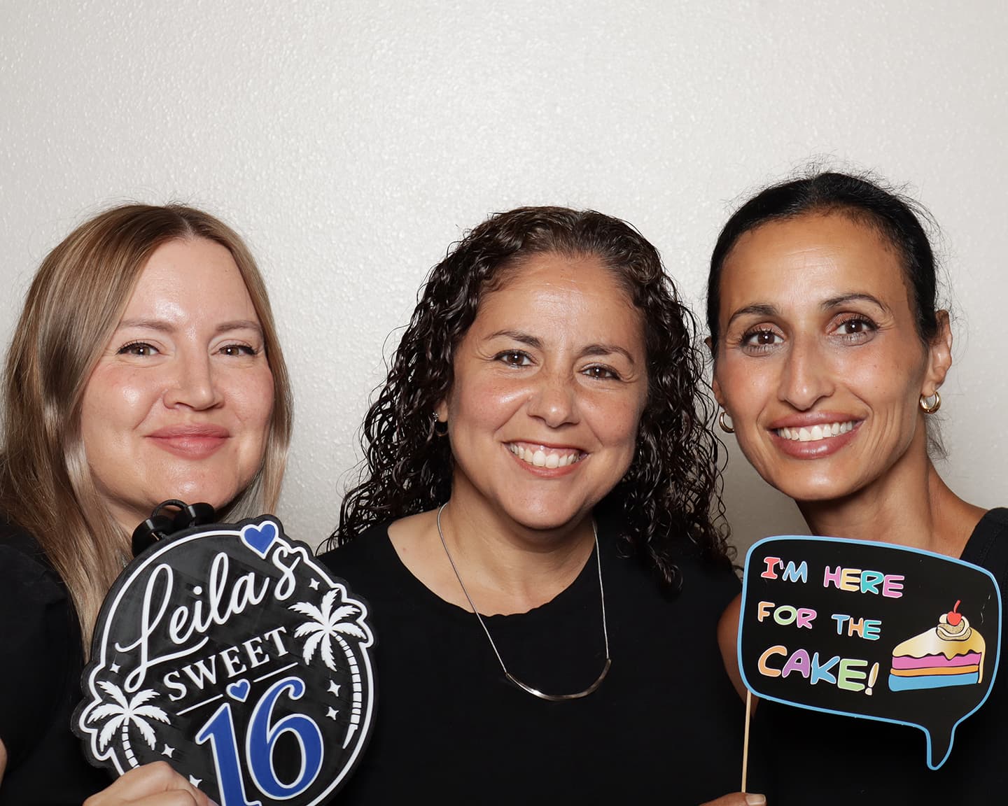 Tampa party guests posing with Sweet 16 props in a professional photo booth